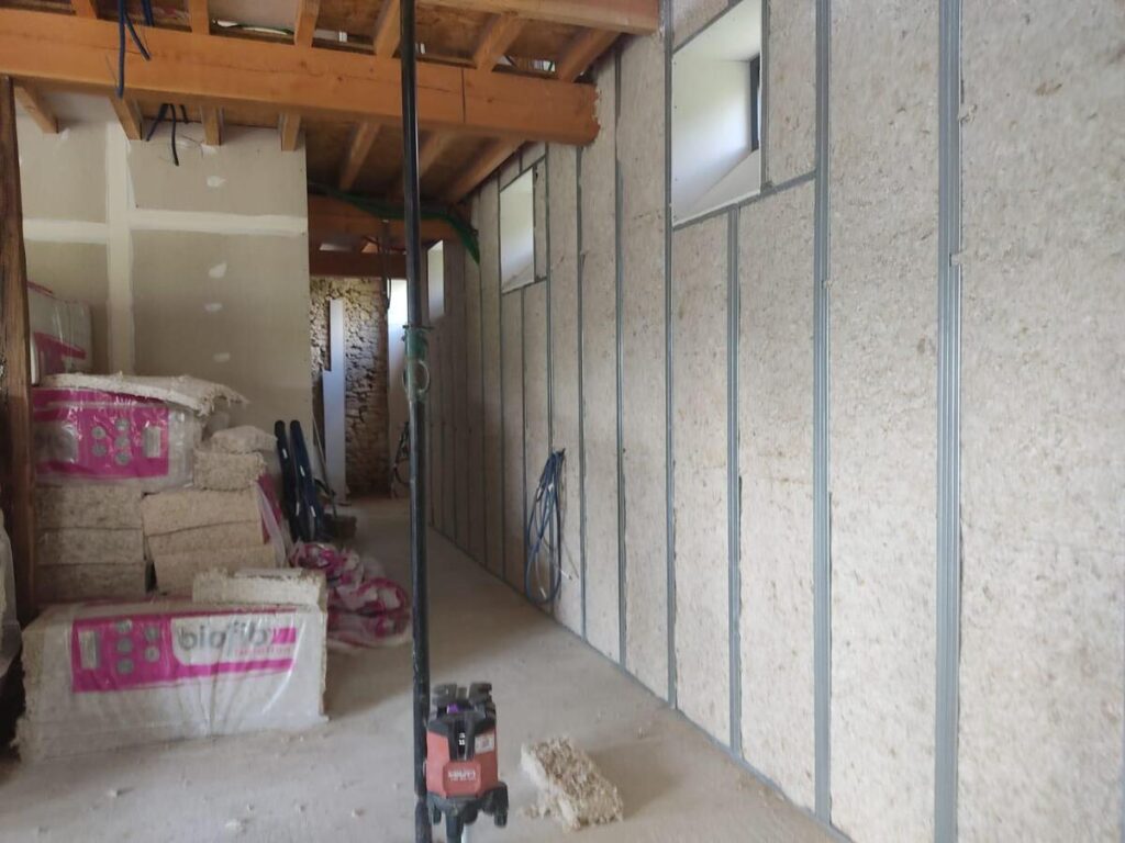 Chantier isolation intérieure : panneaux isolants fibre de bois "biofib" installés entre ossature métallique pour rénovation de bâtiment ancien.